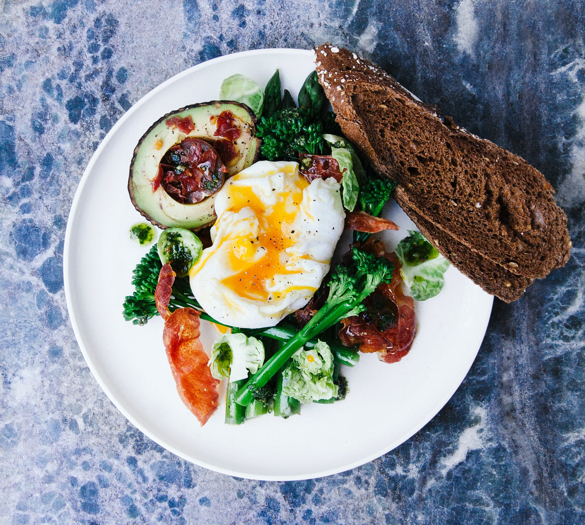 poached egg on greens with avocado and bread