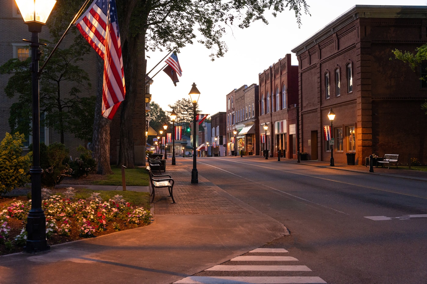 Small-town Main Street decorated with American flags at dusk