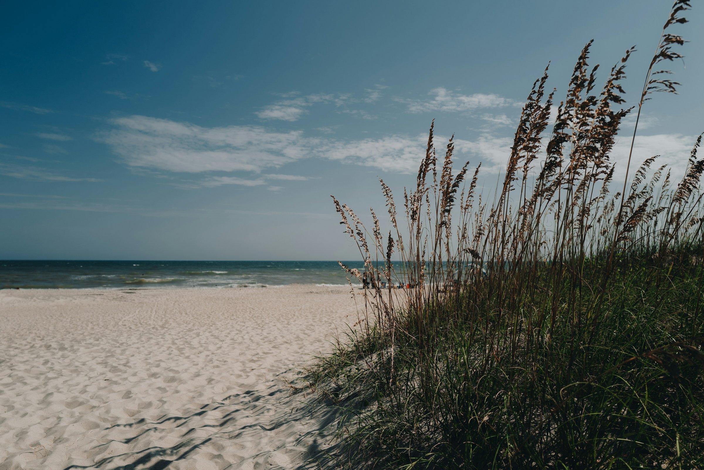 The oceanfront beach at Atlantic Beach, North Carolina on a clear summer morning, with dunes and sea oats in the foreground