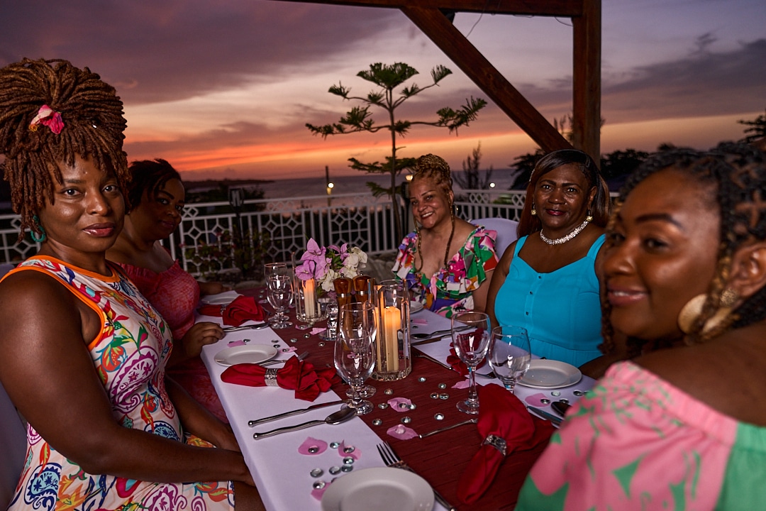 Ladies on retreat in Jamaica having dinner on roof deck at Mais Oui Villa
