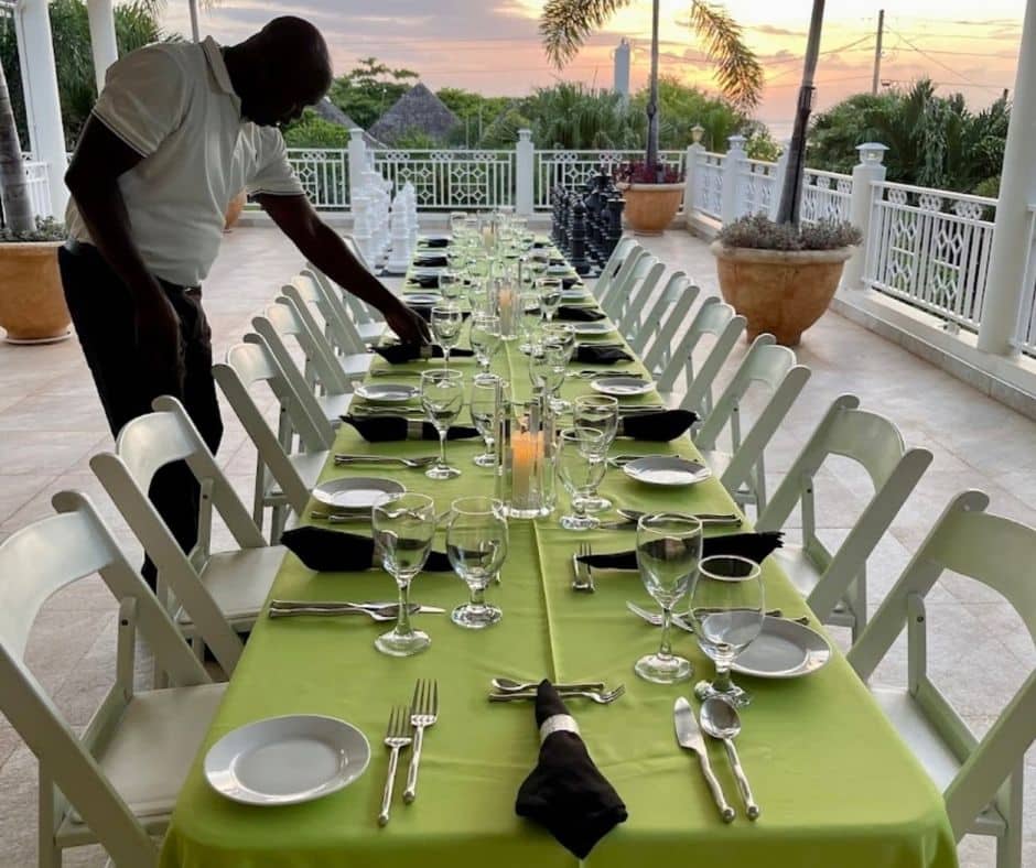 butler setting up table at Mais Oui Villa in Discovery Bay Jamaica for family vacation at a Jamaica family villa