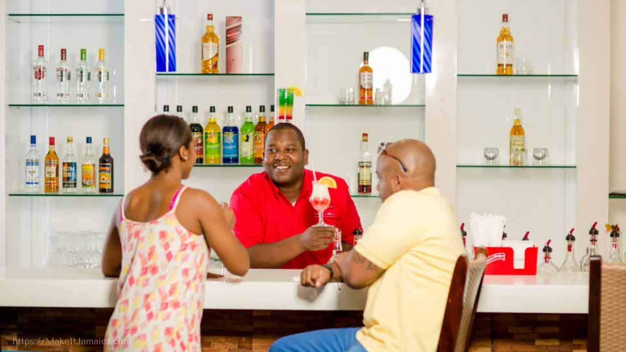 bartender with two guests at the Club Mobay Montego Bay Jamaica departure lounge