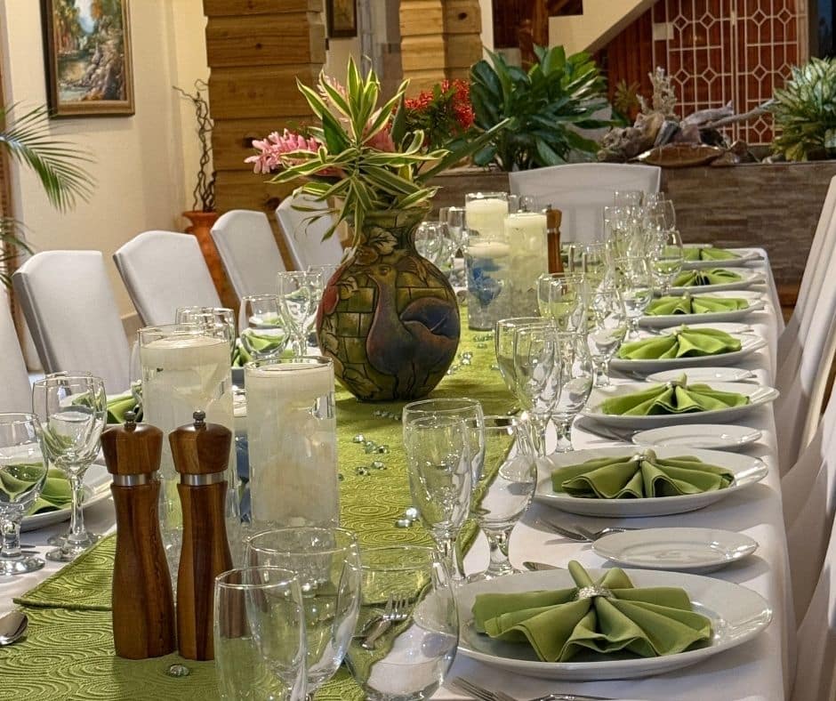 Dining table set up with white tablecloth and green napkins for a luxury birthday celebrationin Jamaica at Mais Oui Villa in Discovery Bay