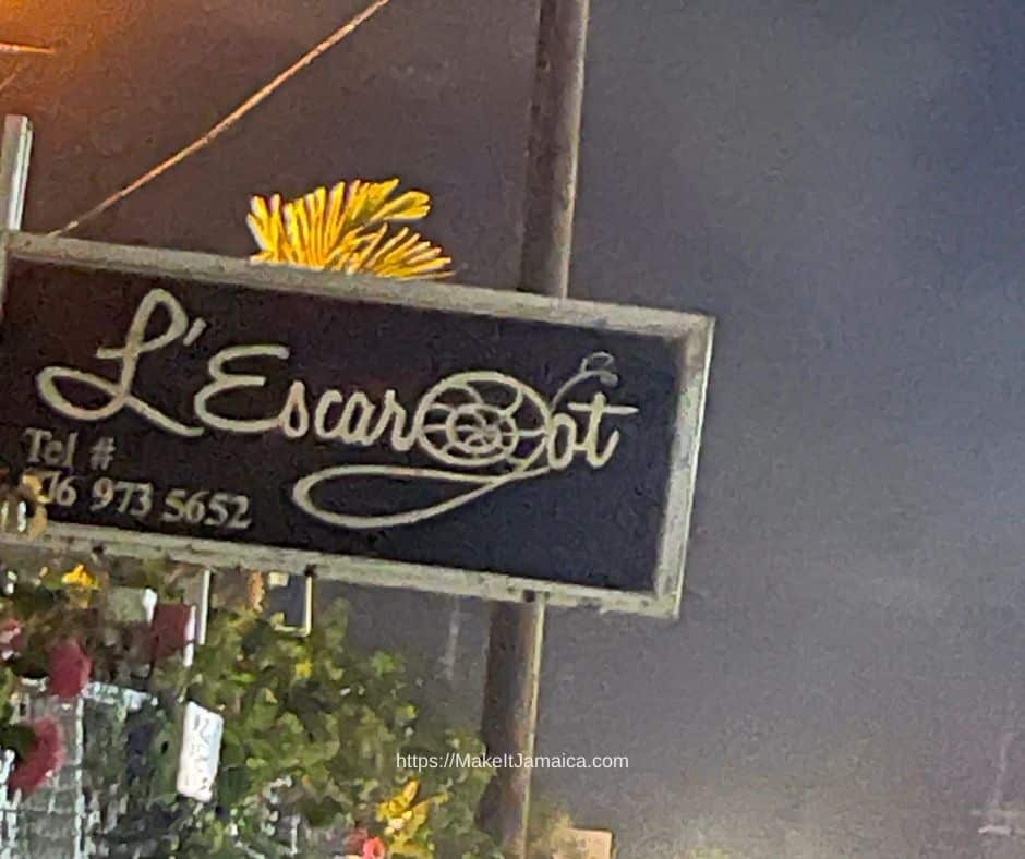 Sign for L'Escargot restaurant in Jamaica located 15 minutes from Mais Oui Villa in Discovery Bay