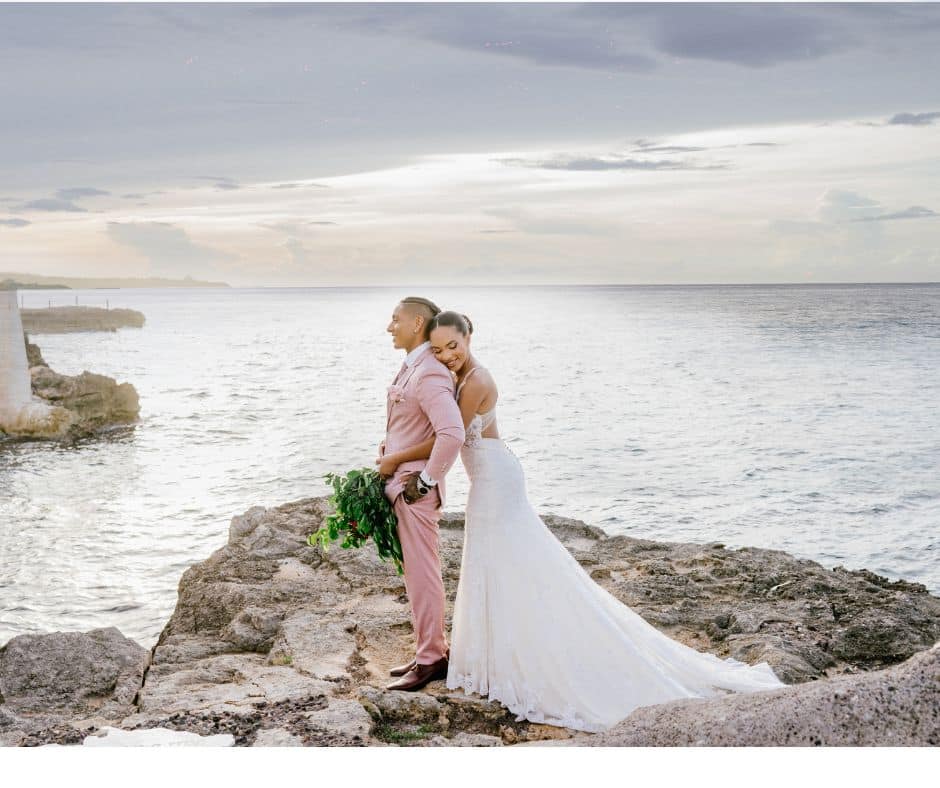 couple standing cliffside at Borghinvilla Jamaica wedding venue walking distance from Mais Oui Villa in Discovery Bay Jamaica for a Jamaica villa wedding with a large guest list