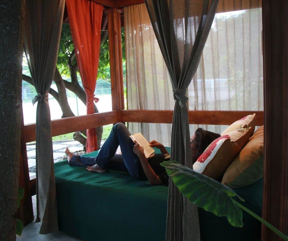 woman reading in the cabana in the garden at Mais Oui Villa in Discovery Bay Jamaica