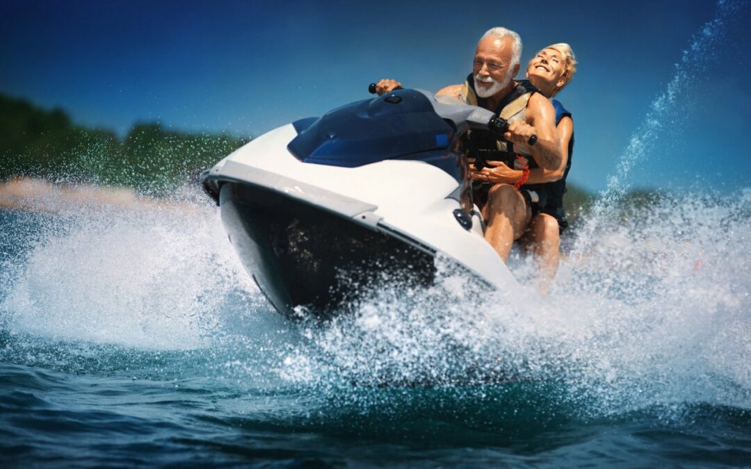 A couple riding a white jet ski across Lake of the Ozarks, spraying water as they turn