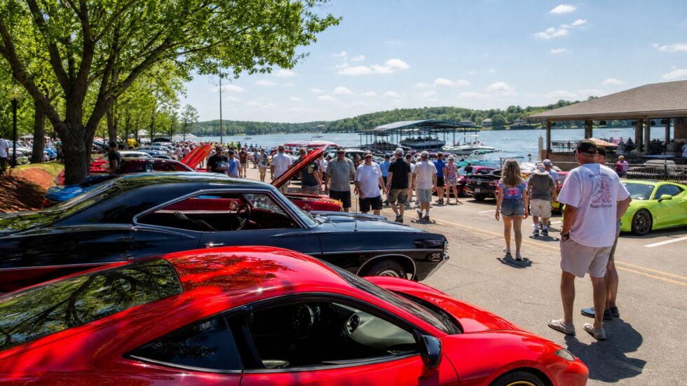 Classic cars lined up at the Magic Dragon street meet near Lake of the Ozarks with the lake in the background