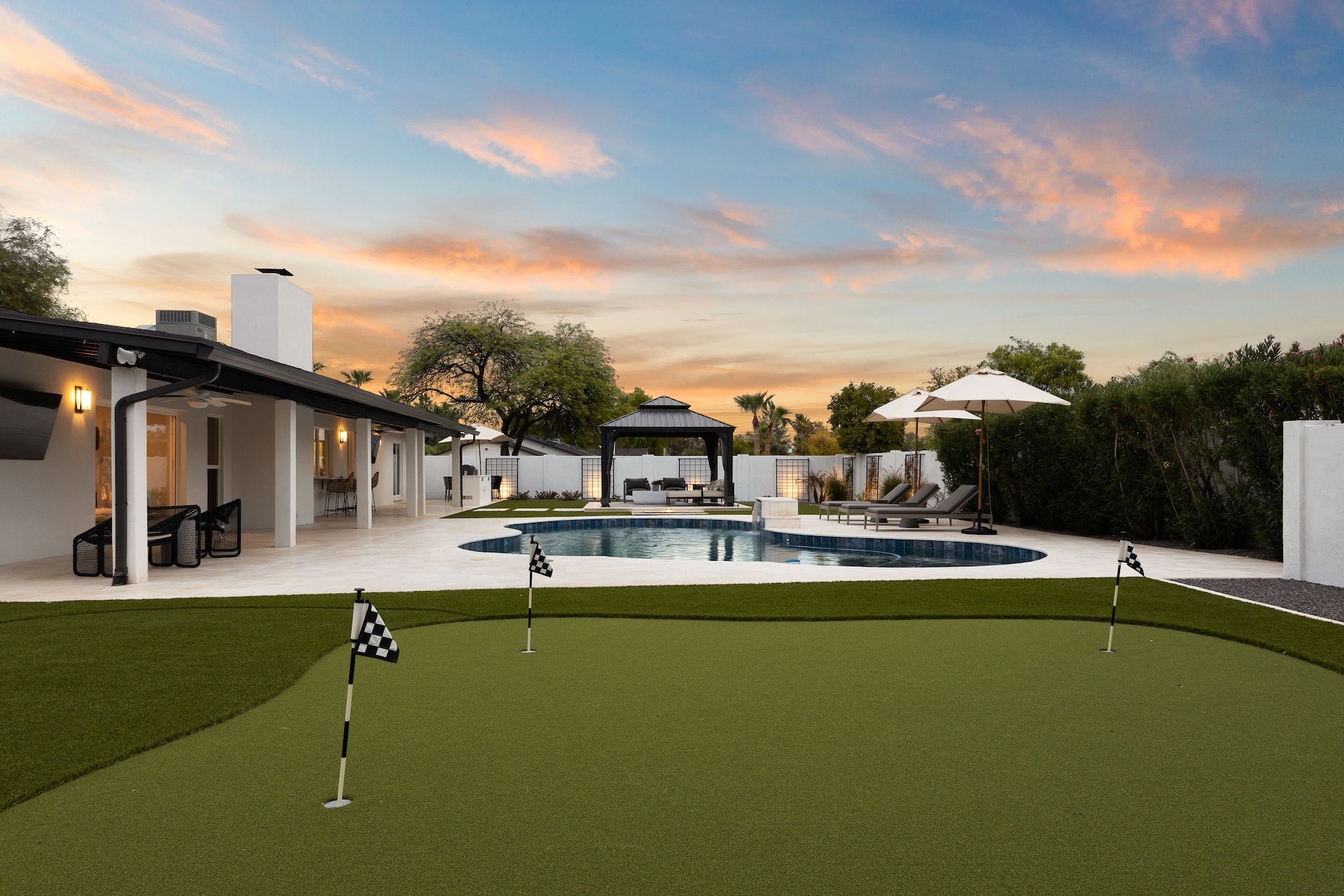 Scottsdale Clubhouse pool, spa, putting green, and covered outdoor lounge at sunset