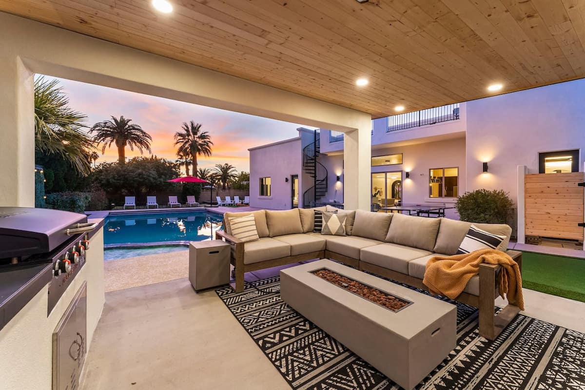 Covered outdoor lounge overlooking the pool at sunset