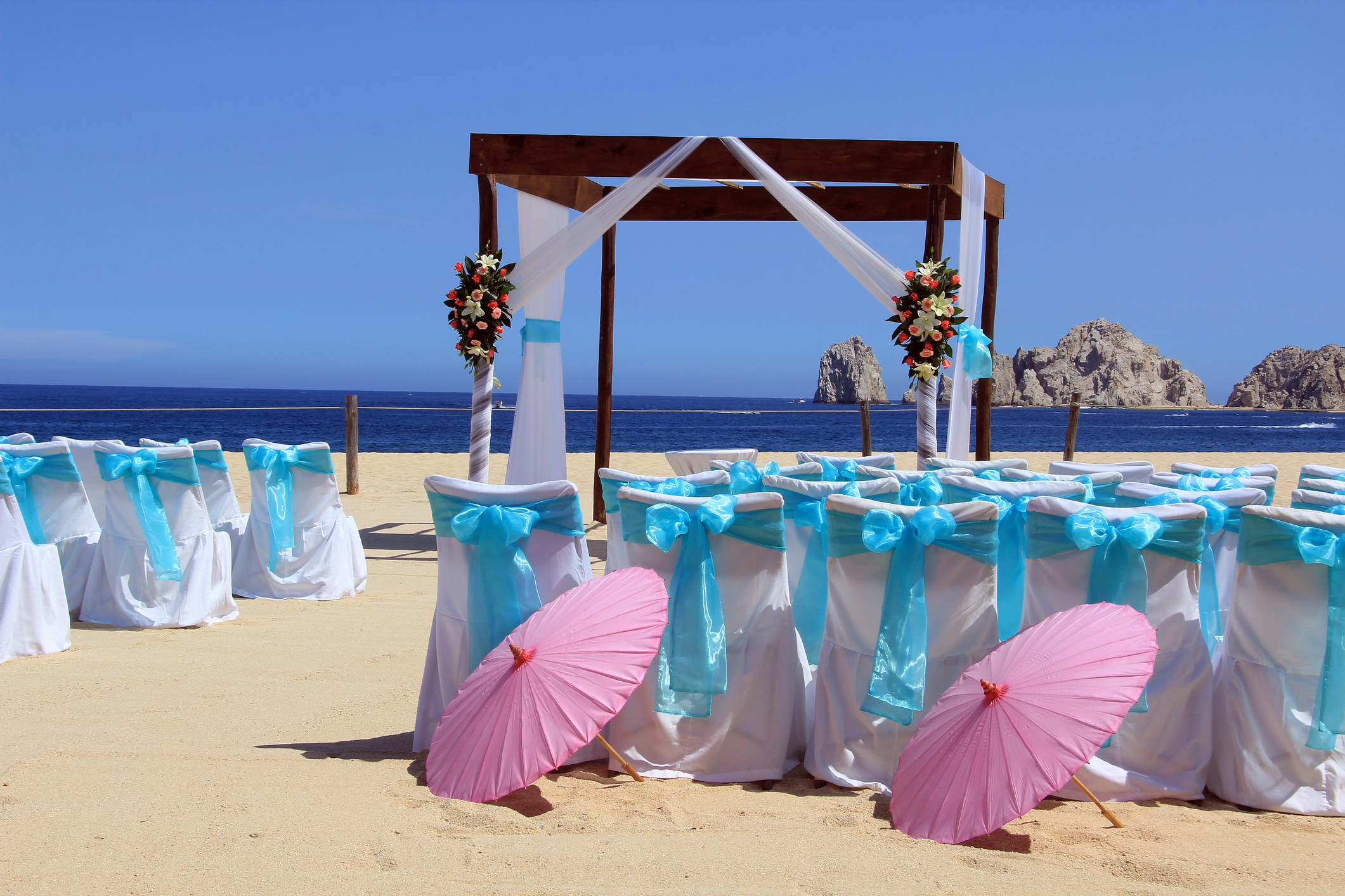Montaje de una ceremonia de boda en la playa con la formación rocosa de El Arco al fondo, Cabo San Lucas