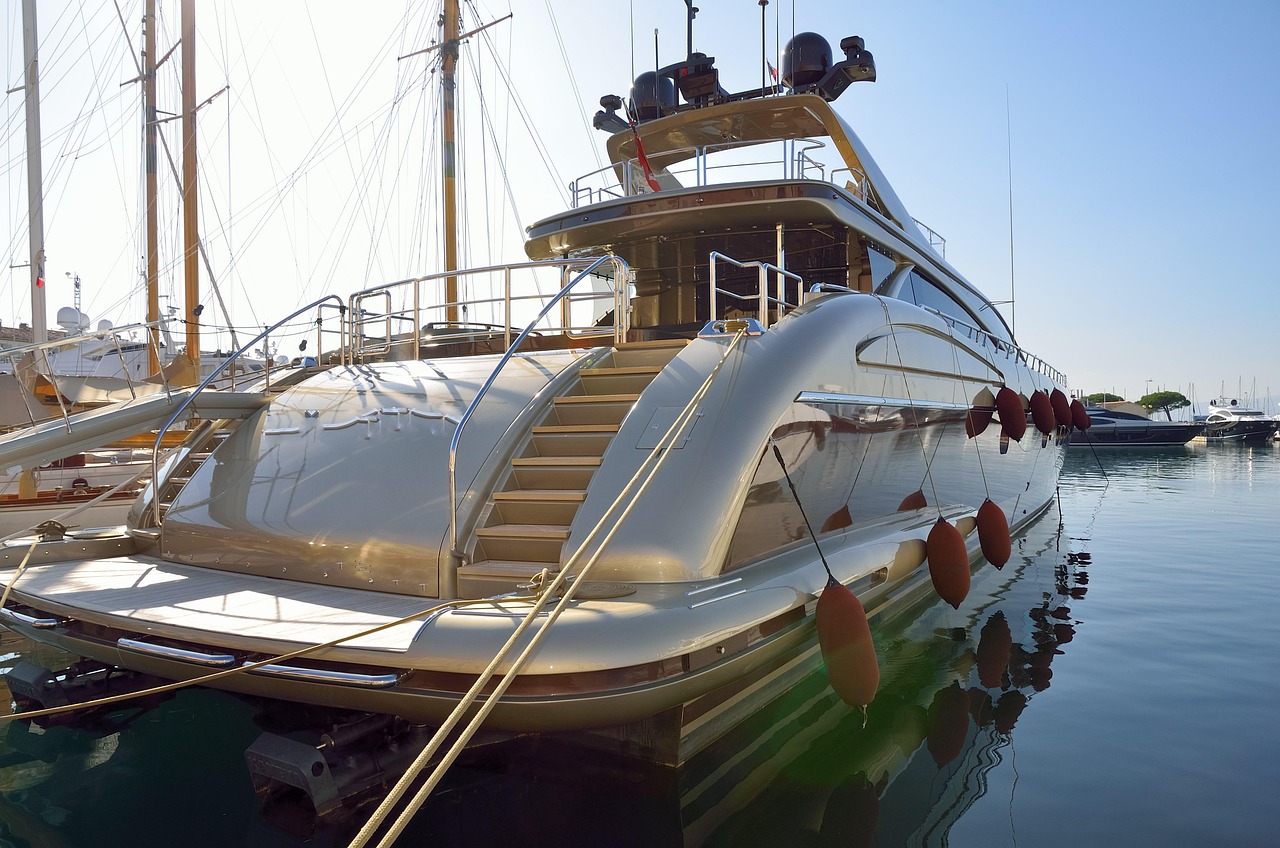 Yate a motor de lujo amarrado en un puerto deportivo, con una superestructura de varias cubiertas y detalles cromados