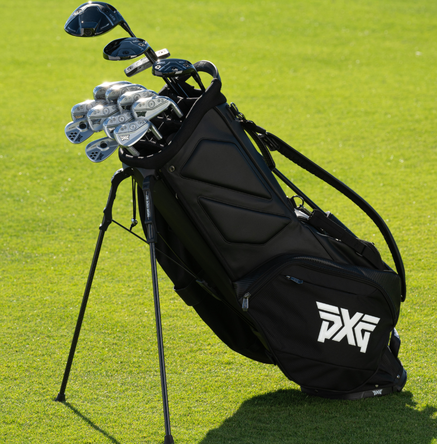 Bolsa negra de golf con soporte y un juego completo de hierros y un driver sobre una calle verde