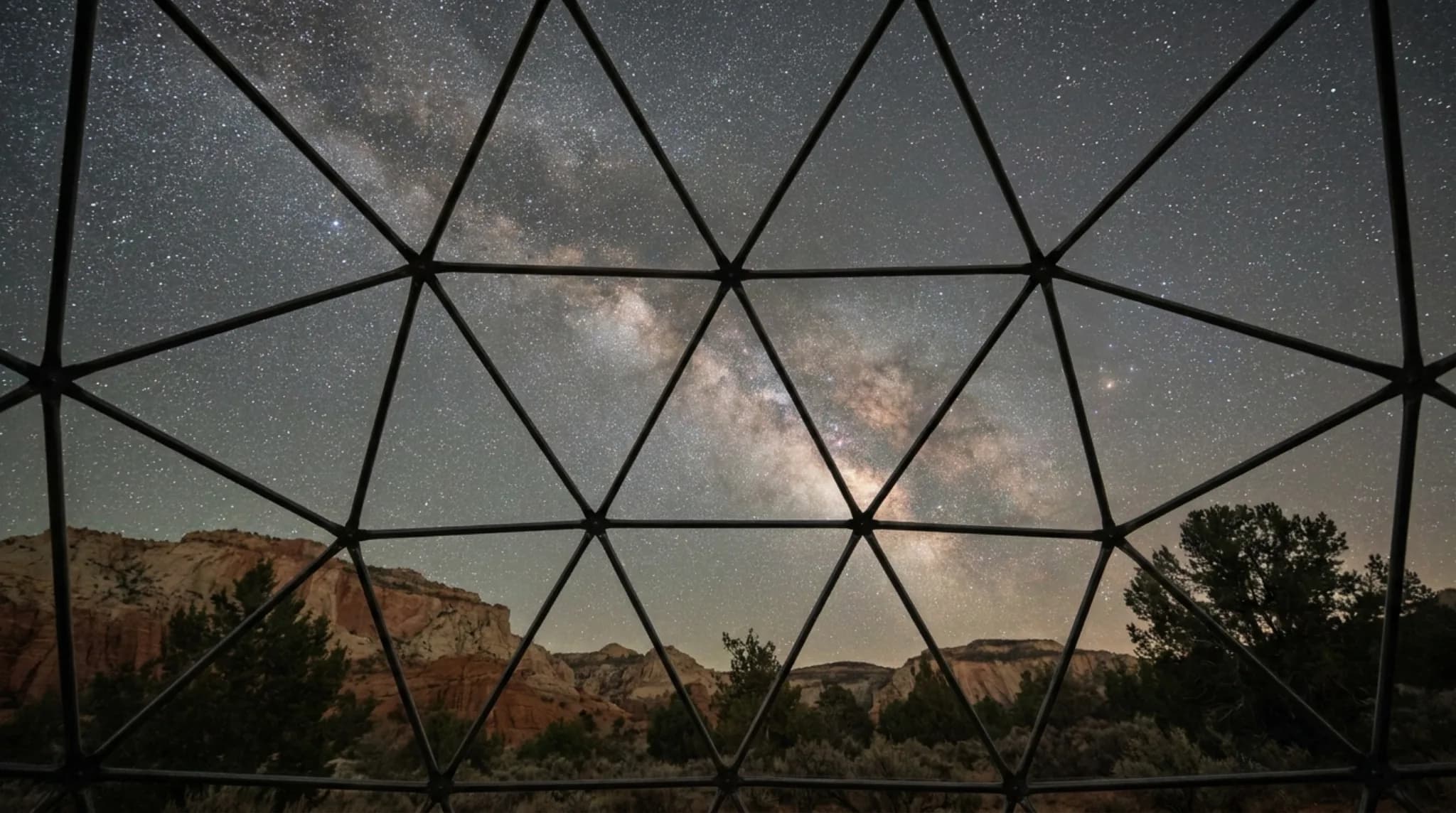 Visualisation of the Milky Way over sandstone cliffs, seen through the triangular glass panes of a planned geodesic dome
