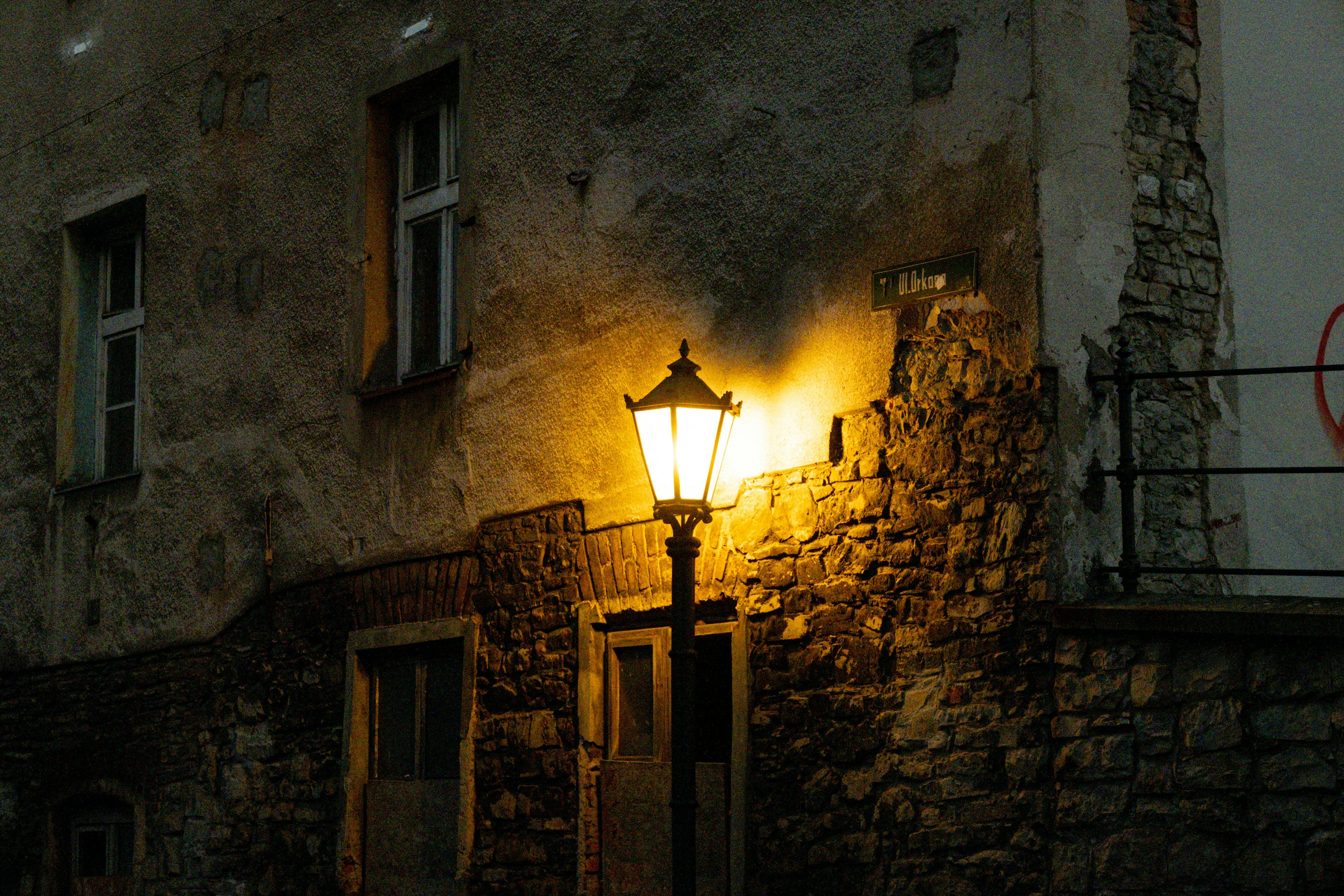 Glowing lantern on a stone wall at night