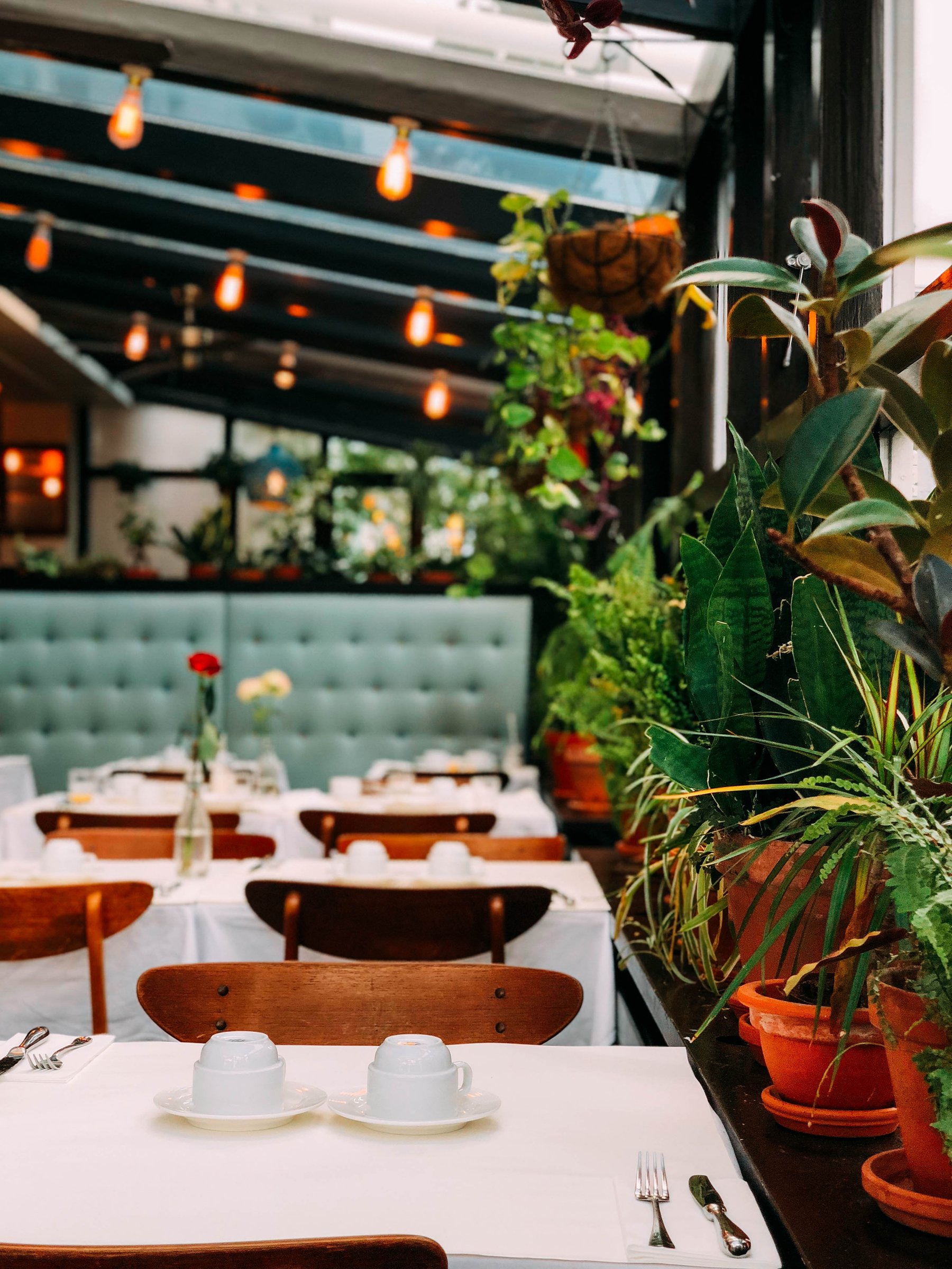 restaurant with white table cloths and green booth