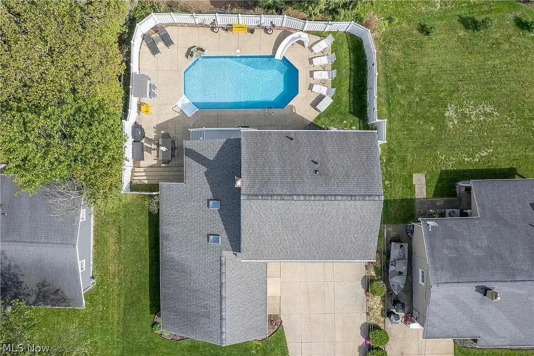 Aerial view of a vacation rental home featuring a private inground pool and fenced backyard designed for family safety and outdoor relaxation