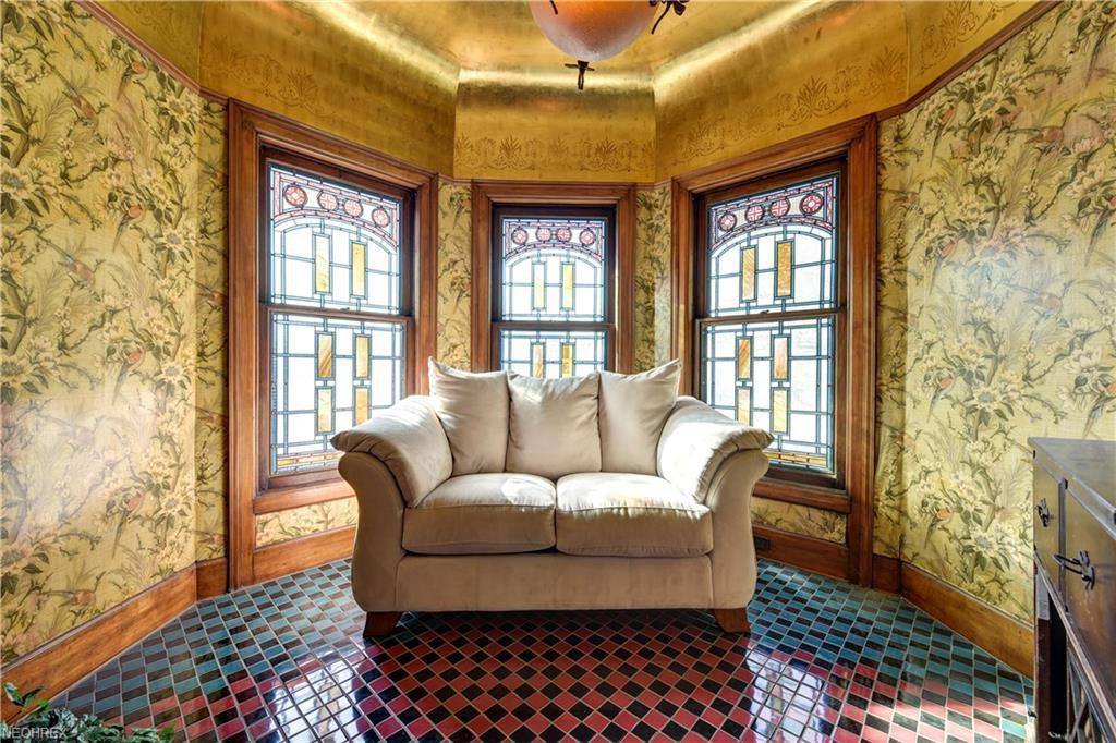 historic sitting room with stained glass windows, natural light, and elegant vintage charm