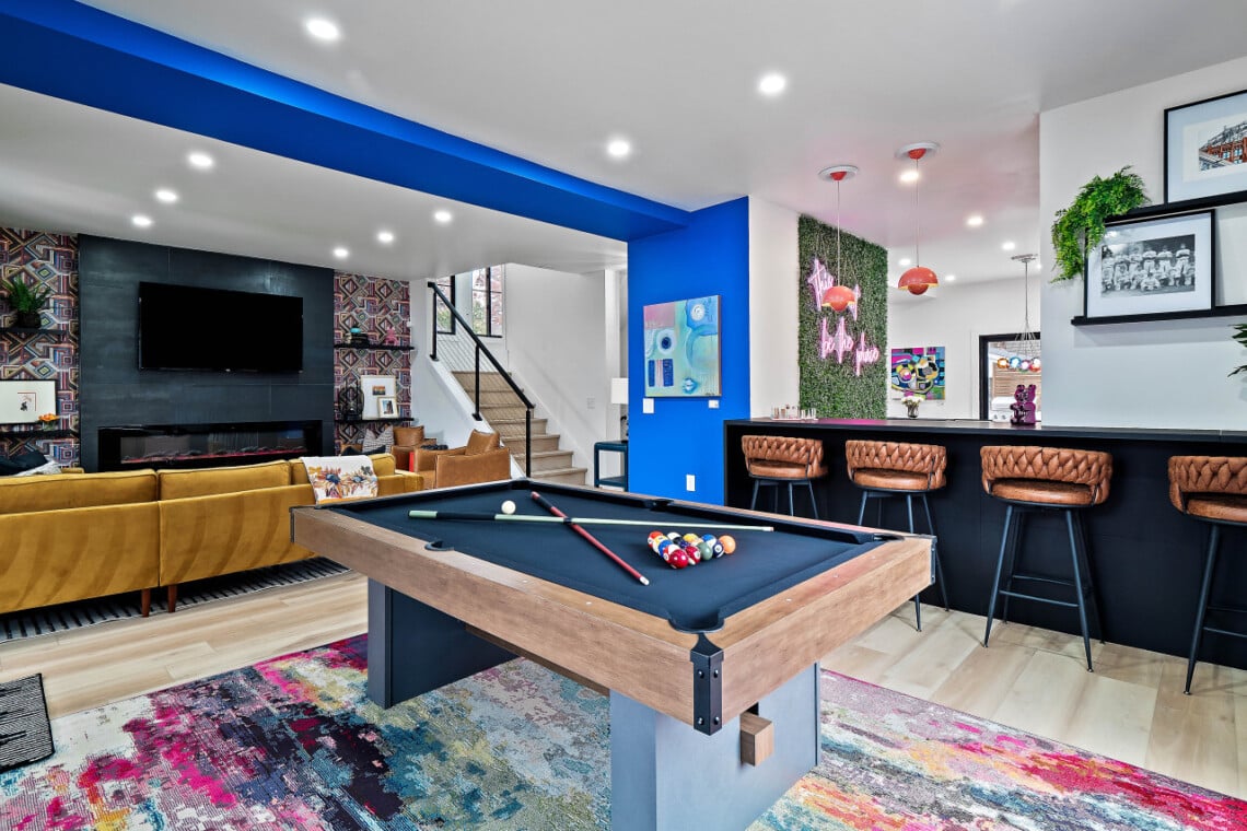 Open-concept living room and game room with pool table and TV in a short-term rental