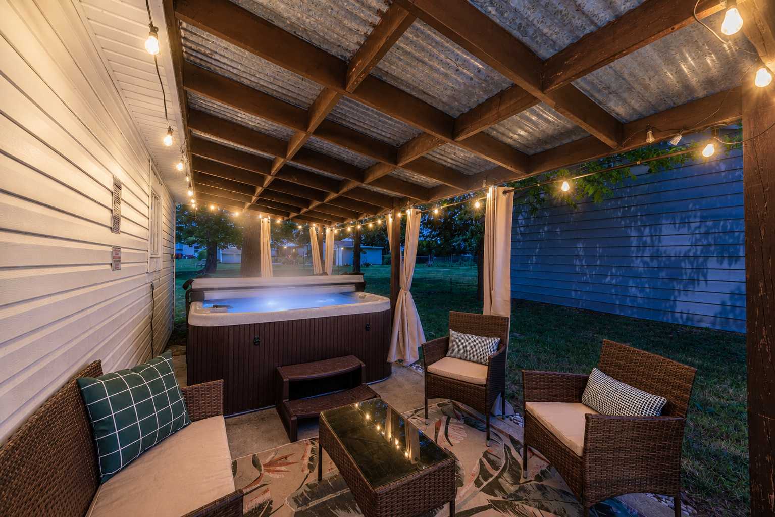 private backyard hot tub with ambient lighting creating an intimate outdoor retreat at a vacation rental