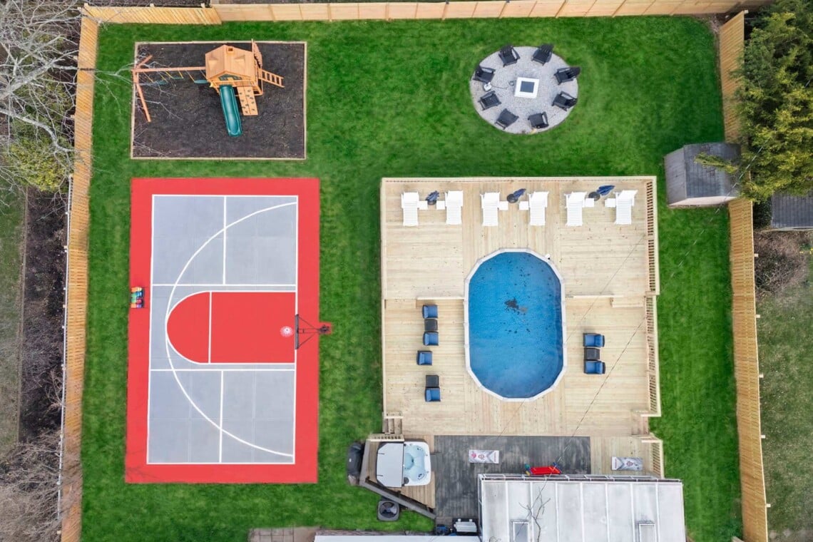 luxury short-term rental backyard with pickleball court, basketball court, firepit, hot tub and playground