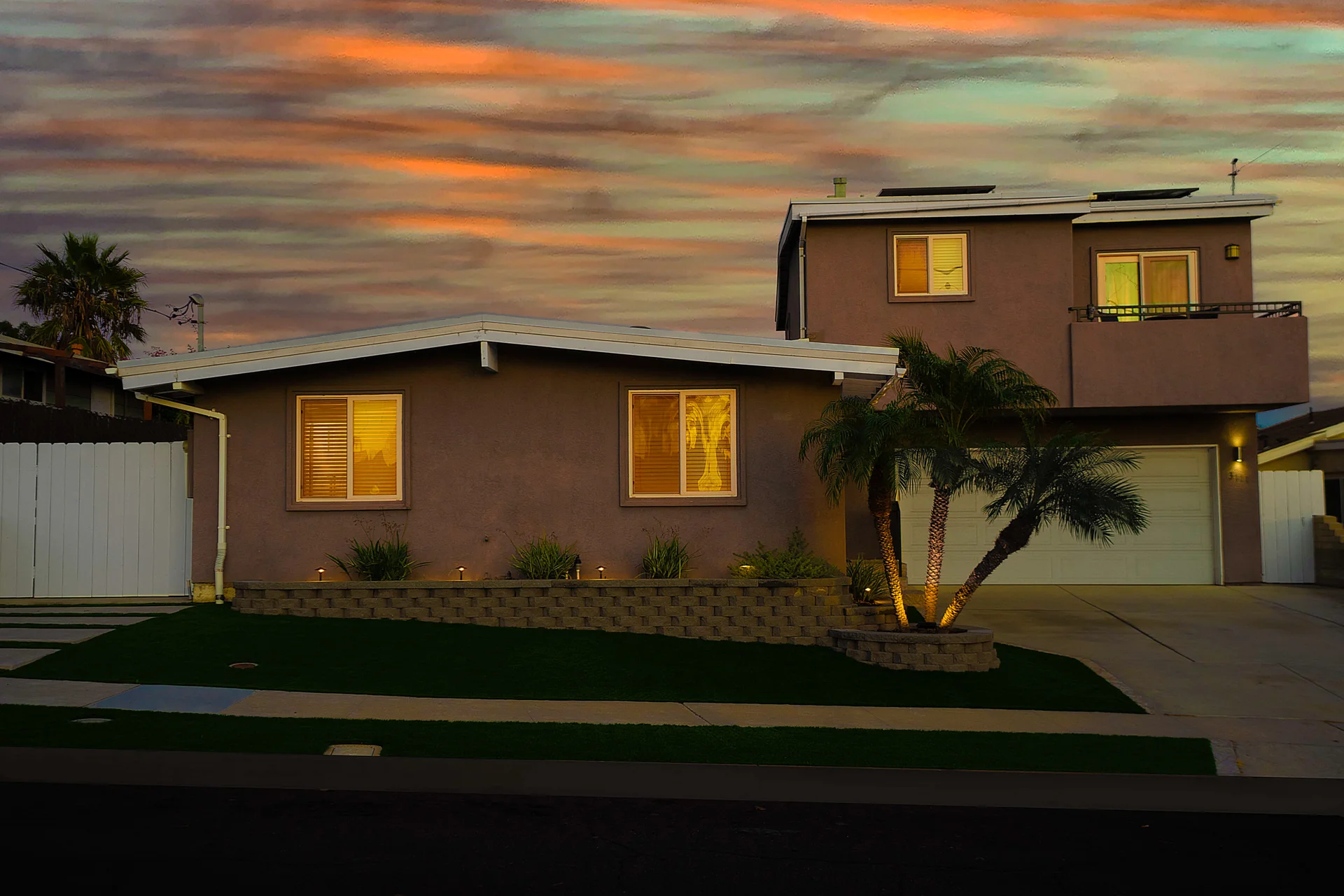 Modern San Diego residential property with terracotta stucco exterior and double garage at sunset, representing investment