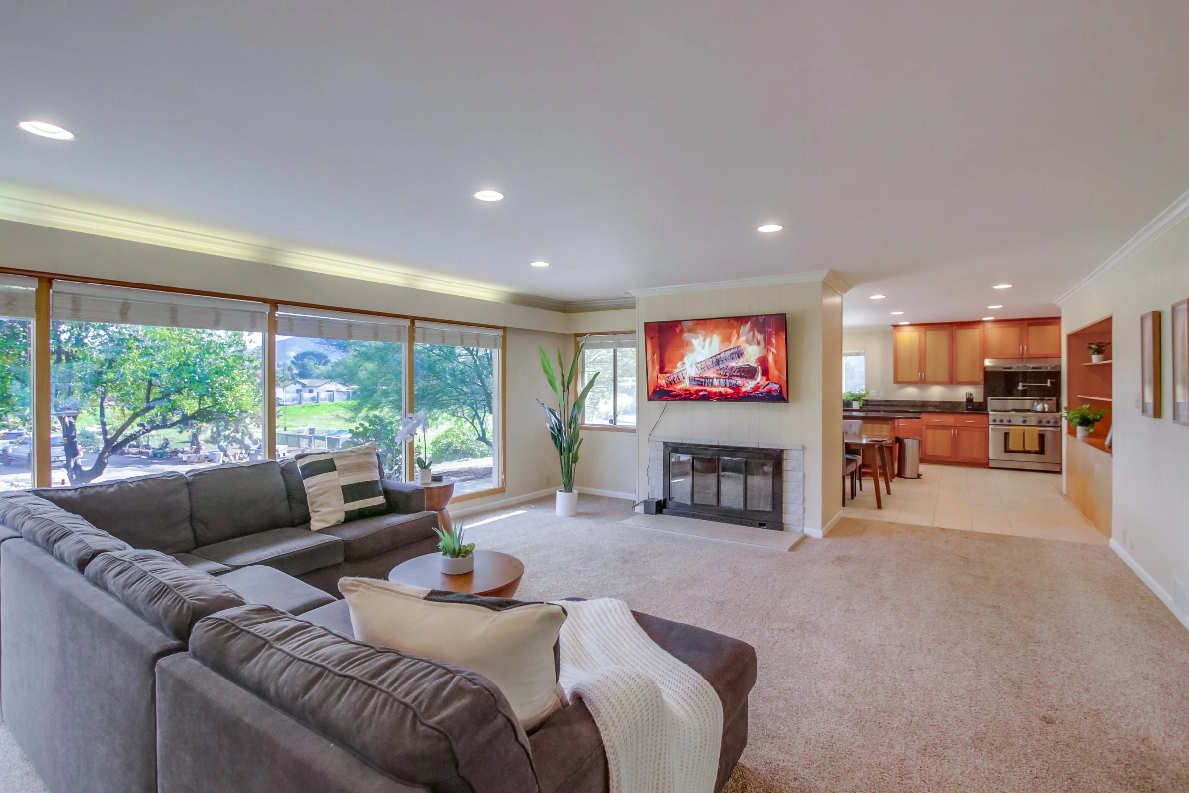 Modern San Diego short-term rental living room with sectional sofa, fireplace, and open kitchen showcasing what matters when