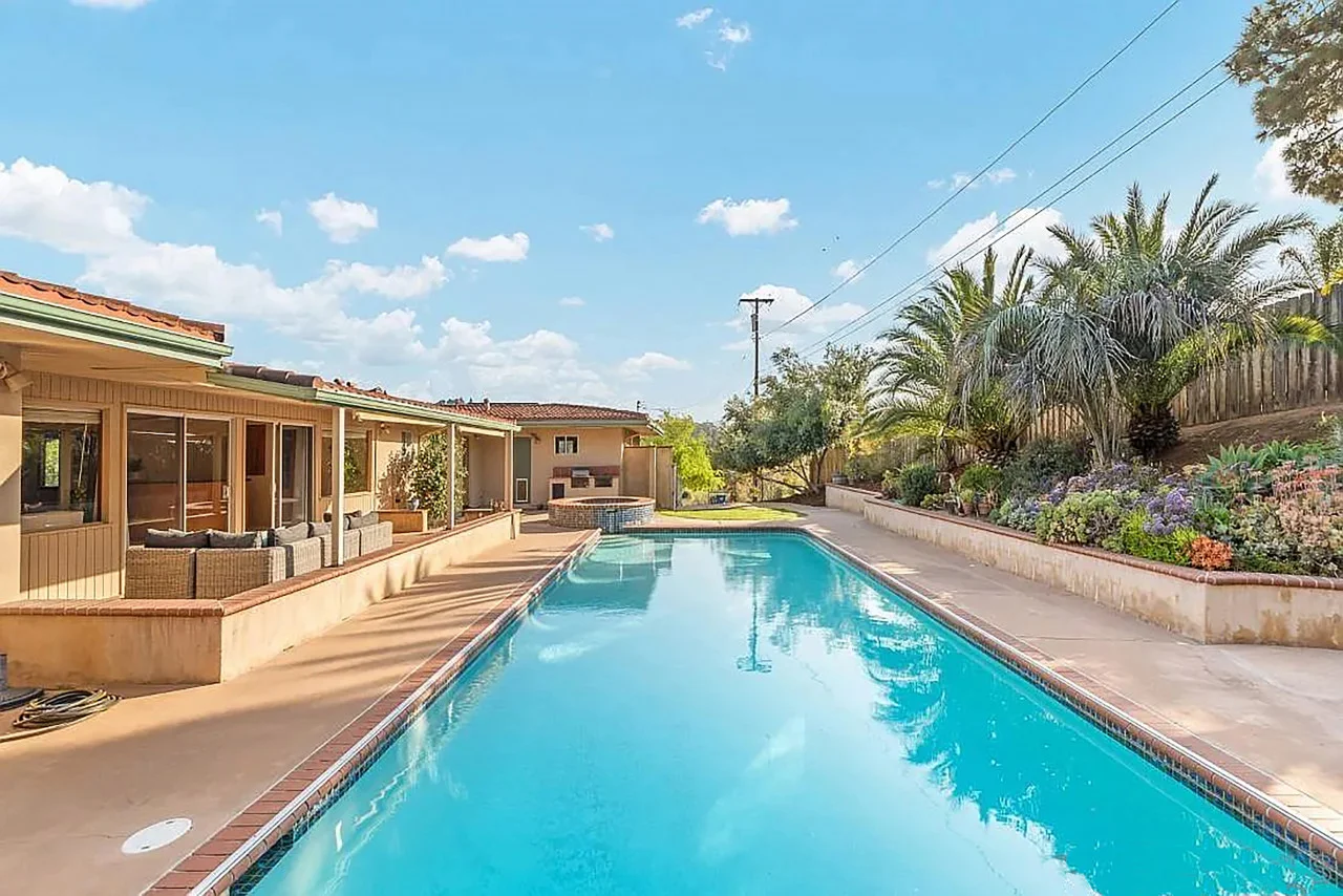 Resort-style swimming pool with turquoise water and tropical landscaping at a San Diego Mission Beach vacation rental