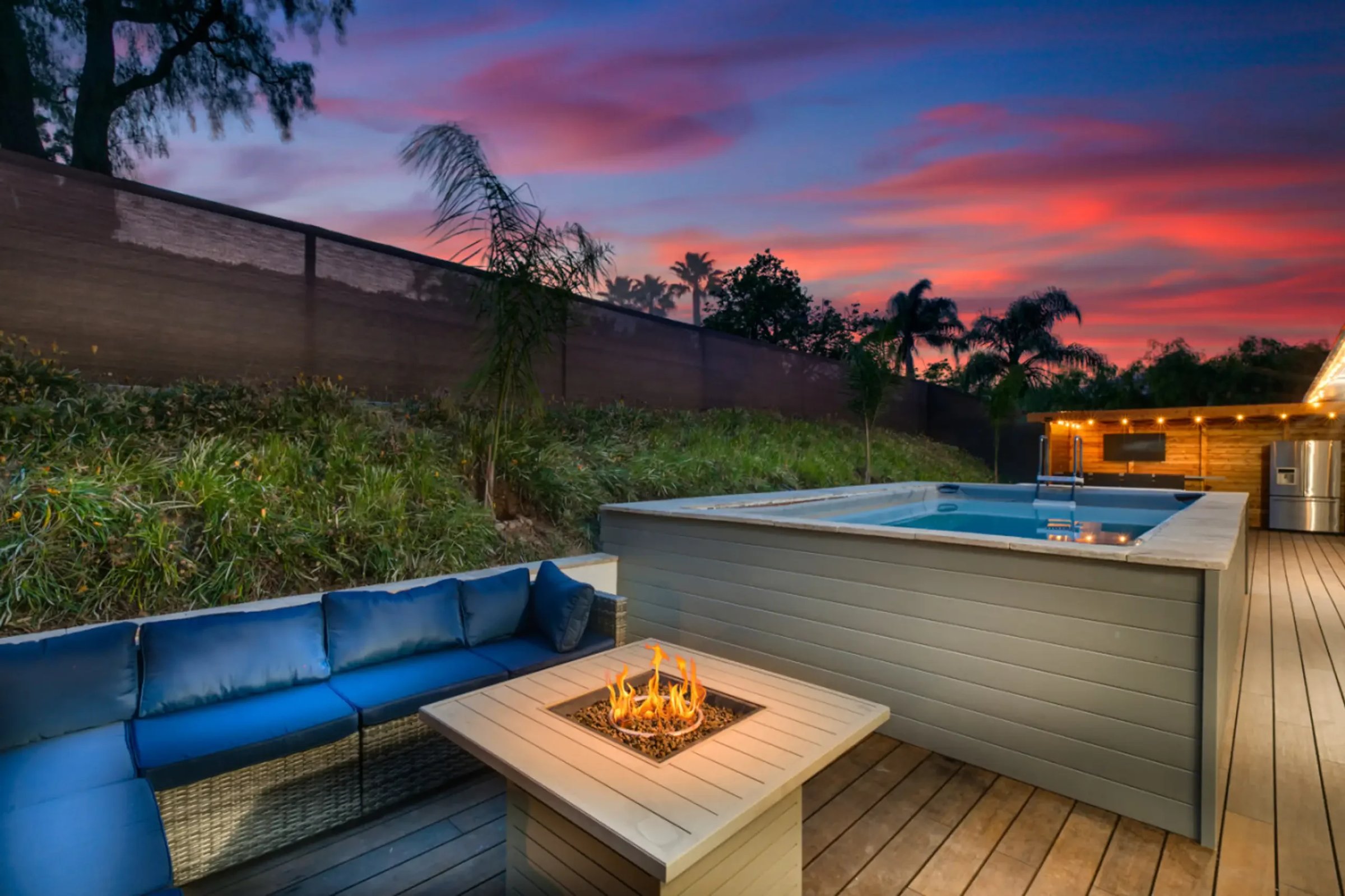 Modern backyard with fire pit, hot tub and deck representing premium property features for short-term rental management