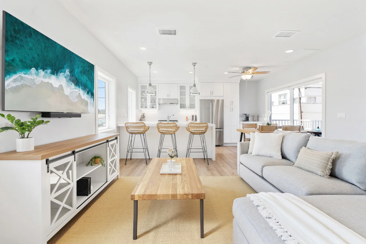 Coastal-modern open-concept living space with kitchen island and ocean-view artwork in San Diego