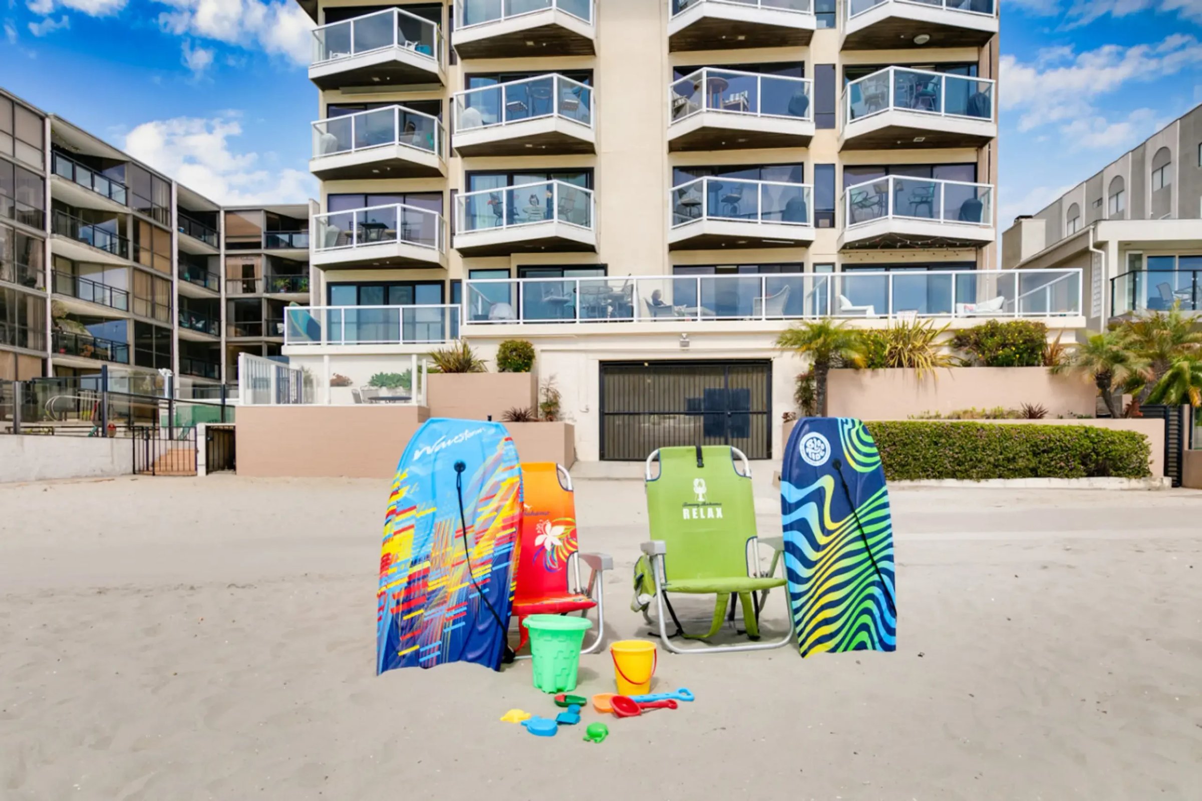 Modern beachfront property in San Diego with colorful beach toys and amenities displayed on sand, showing contemporary