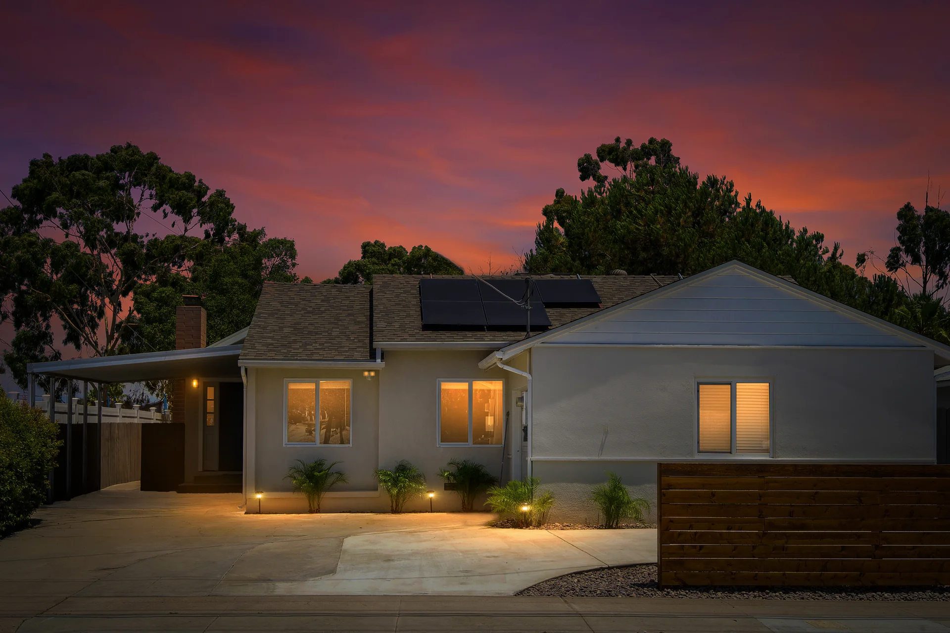 Modern San Diego home exterior with solar panels and twilight lighting for first time Airbnb host