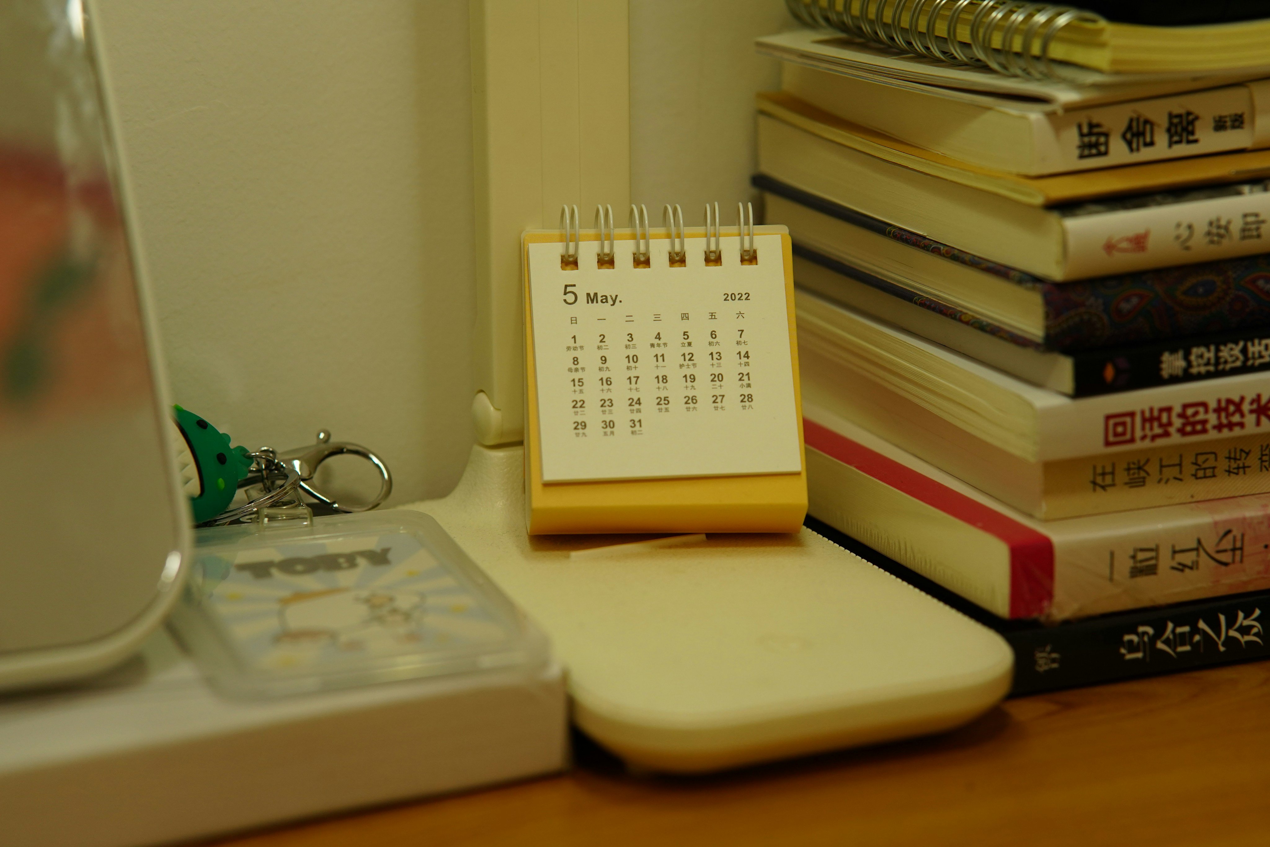 Small desk calendar beside a stack of books