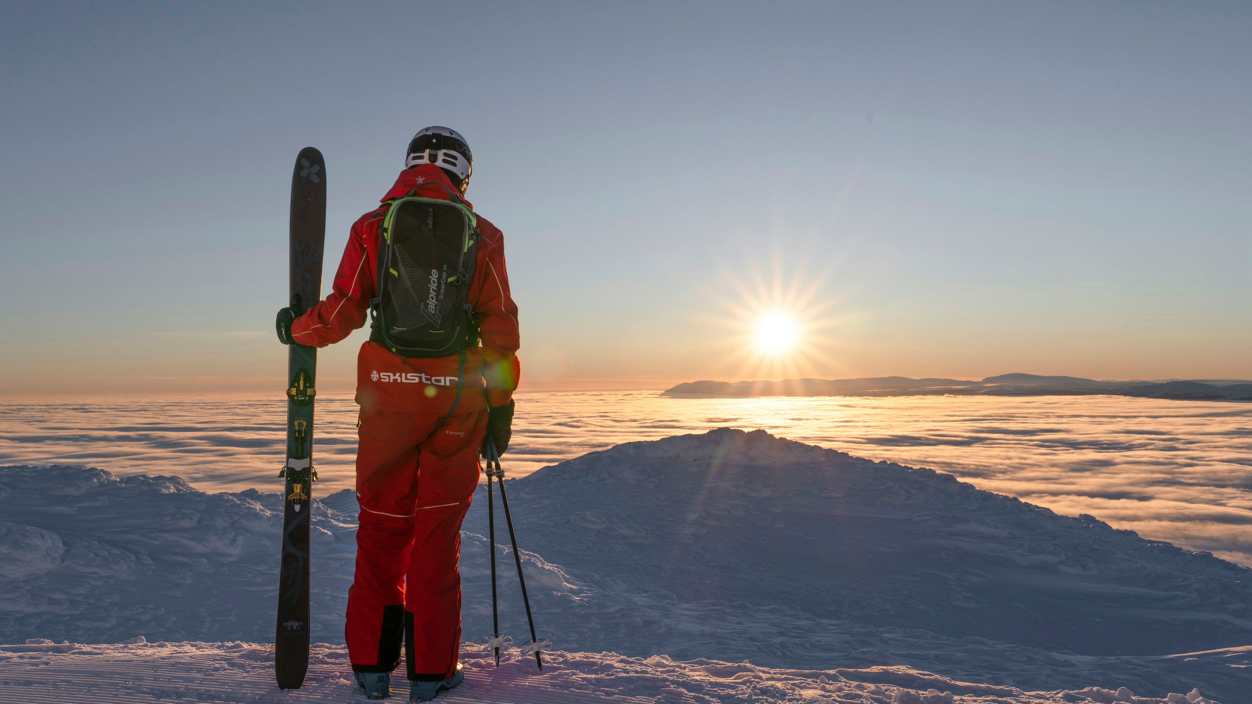 Skier holding skis on a snowy slope