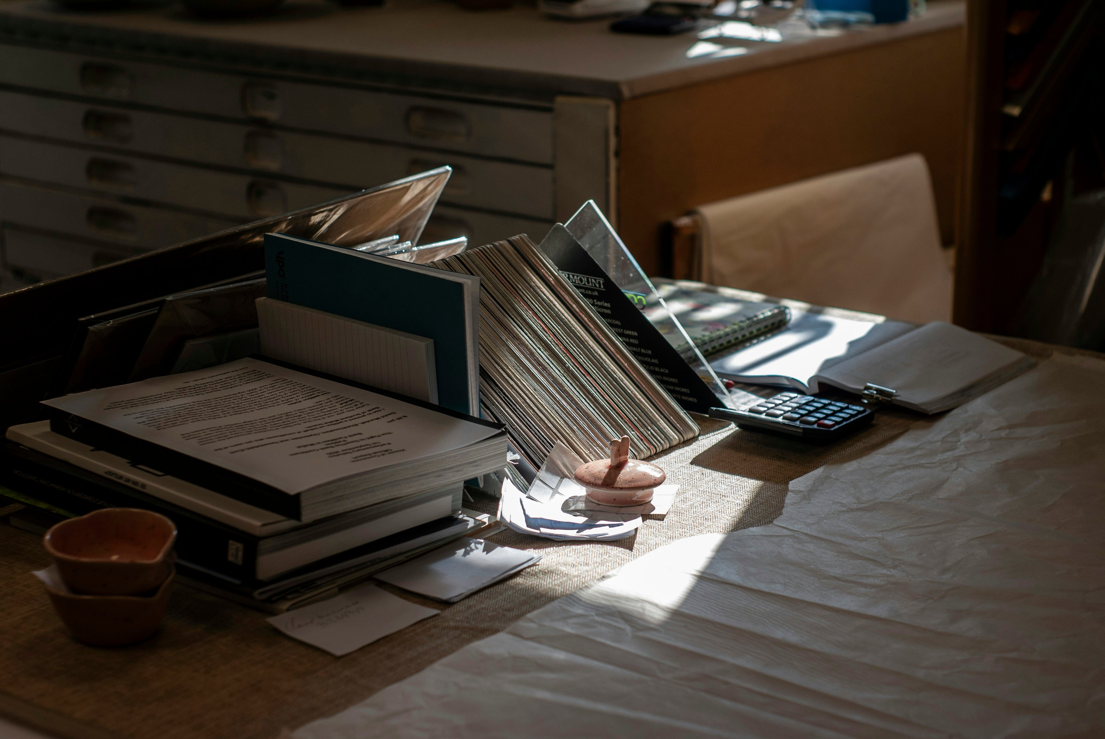 Desk with books, papers and a calculator