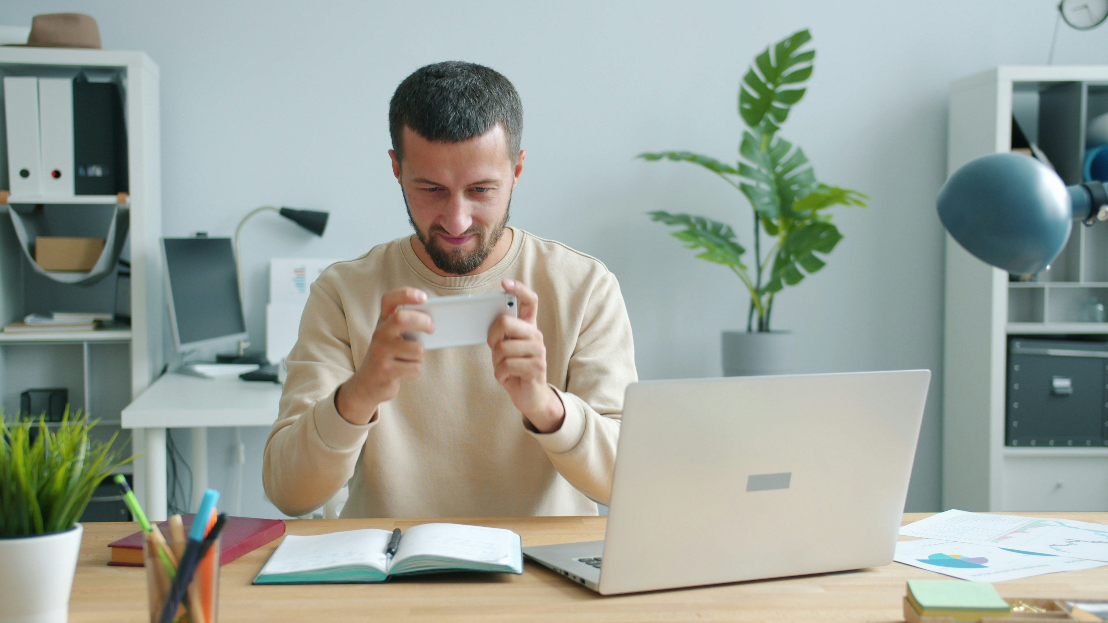 Person holding a card at a desk with a laptop