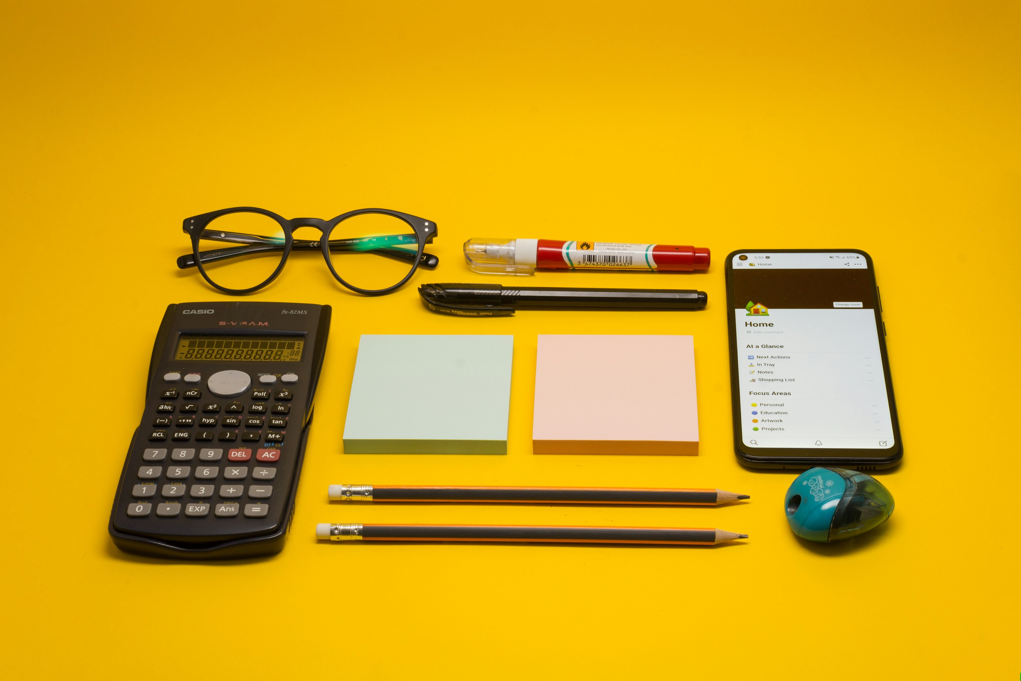 Calculator, pen, glasses and notepad on a desk
