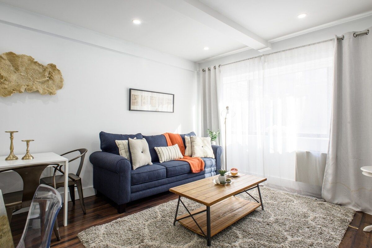 Living room with blue sofa, wooden coffee table, and cream rug.
