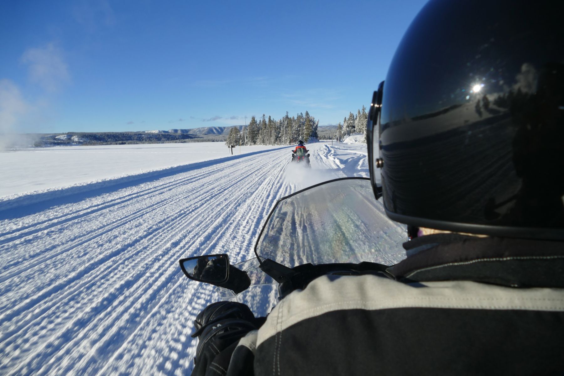 snowmobile driver's view of snowy trail