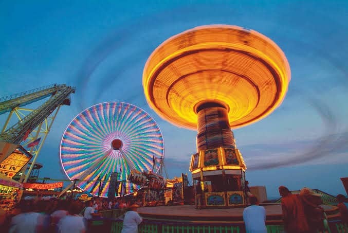 Amusement rides and Ferris wheel at Seaside Heights boardwalk, Jersey Shore vacation destination.
