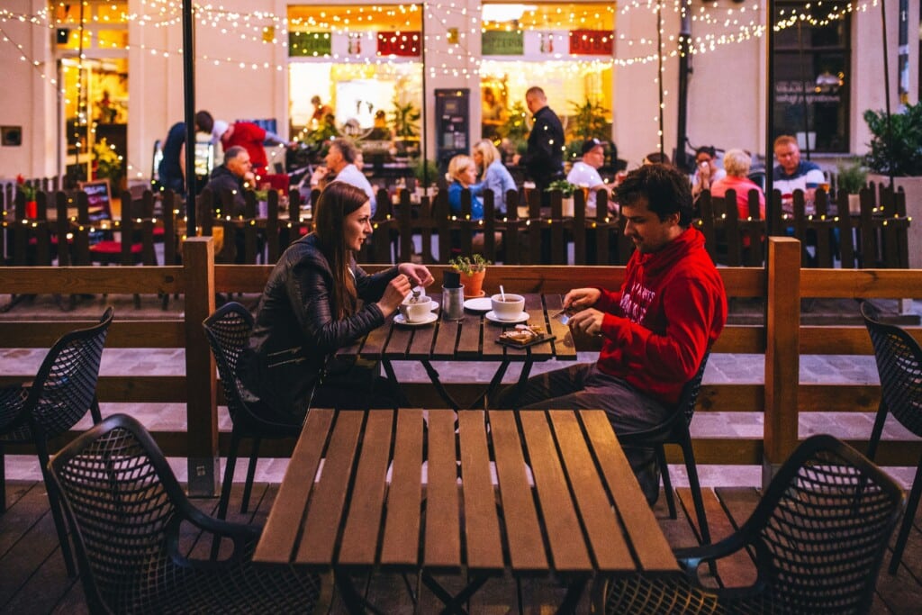 Couple enjoying an intimate dinner at a cozy outdoor restaurant with warm ambiance and string lights, ideal for a romantic getaway in Seaside Heights.