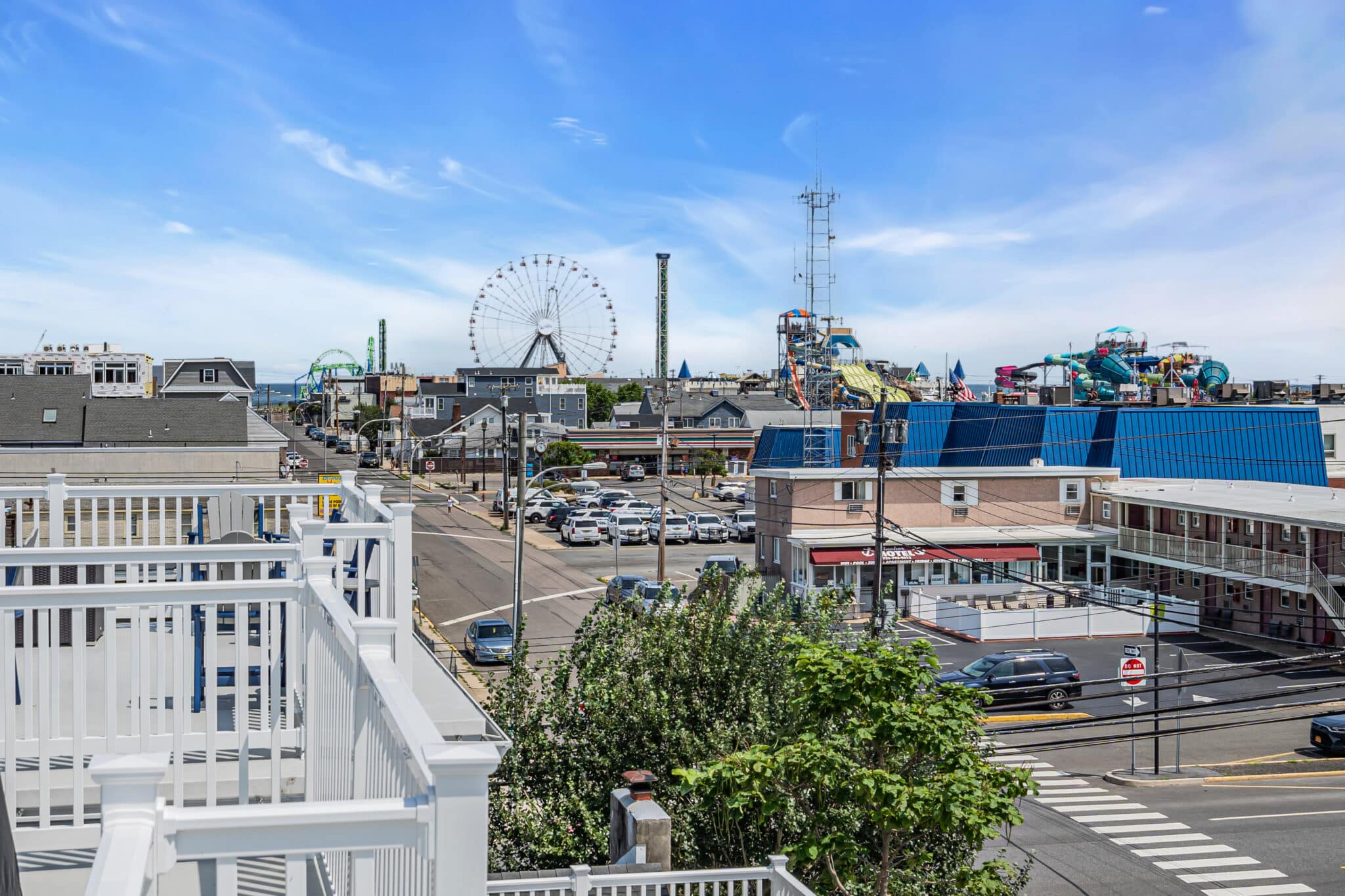 View of Seaside Heights boardwalk with amusement rides, including a Ferris wheel, and nearby attractions, showcasing a vibrant family-friendly atmosphere.