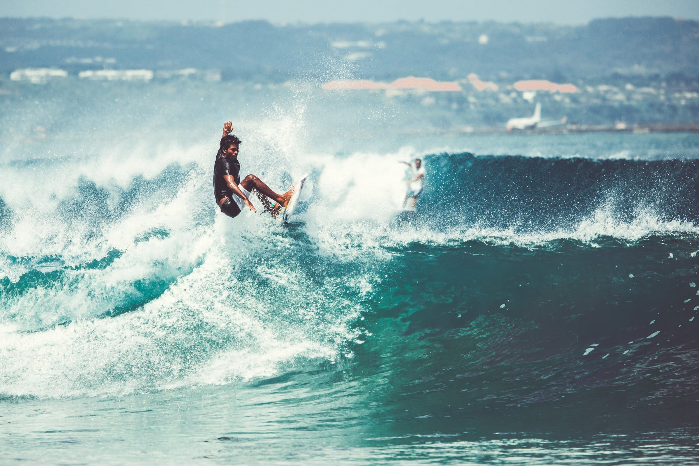 Surfer performing a maneuver on a wave at the Jersey Shore, highlighting the region's vibrant surfing culture and beach activities.