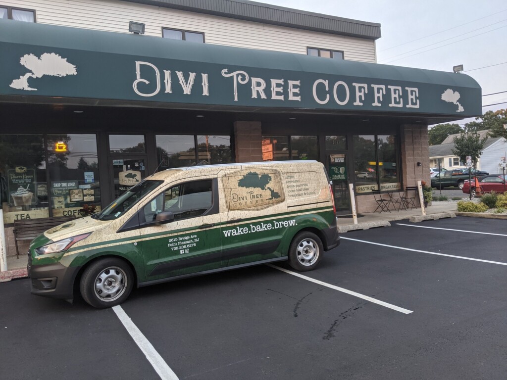 Divi Tree Coffee storefront in Point Pleasant with branded delivery van, showcasing a welcoming atmosphere and focus on organic, small-batch brews.