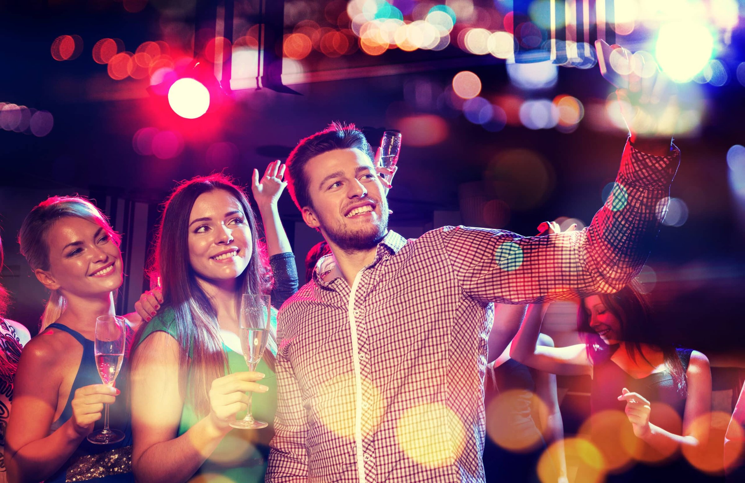 Smiling friends celebrating in a nightclub, holding champagne glasses and taking a selfie amidst colorful holiday lights, capturing the vibrant nightlife atmosphere of the Jersey Shore.