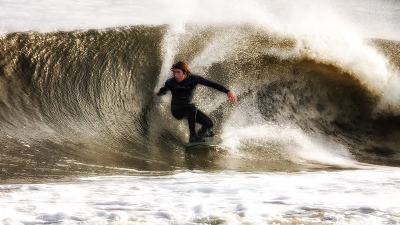 Surfer in a wetsuit riding a wave at the Jersey Shore, showcasing the vibrant surf culture and conditions ideal for year-round surfing.