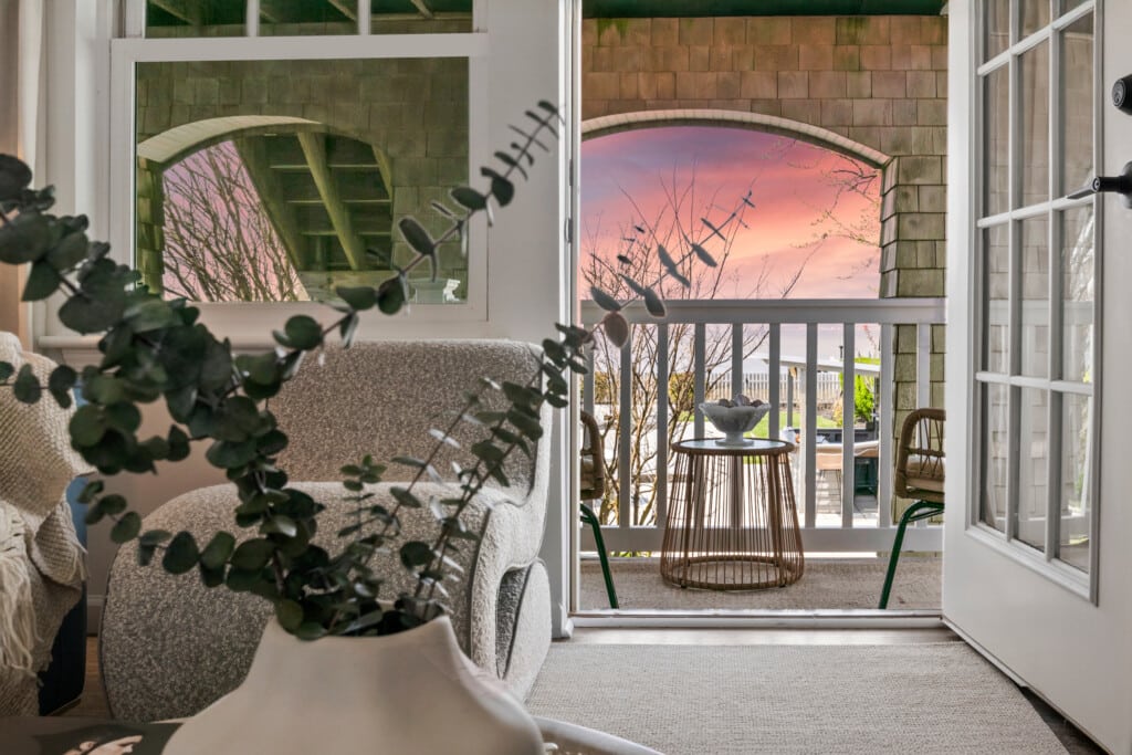Cozy interior view with a plant, showcasing a balcony and sunset over the Jersey Shore, inviting relaxation after a day at local bars.