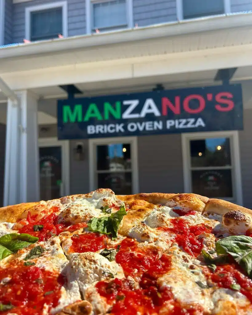 Margherita pizza with fresh mozzarella and basil in front of Manzano's Brick Oven Pizza, Waretown, Jersey Shore.