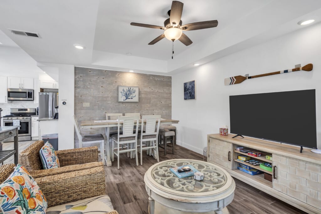 Modern beach rental interior with open layout, featuring a dining area, kitchen appliances, comfortable seating, and coastal decor, ideal for vacation stays near Lavallette.