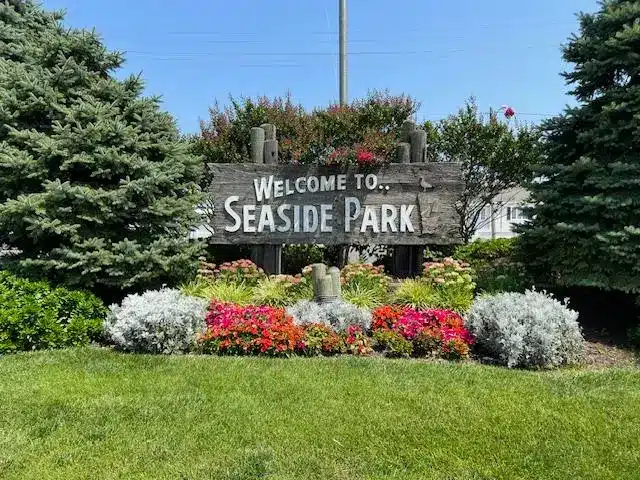 Welcome sign for Seaside Park surrounded by colorful flowers and greenery, highlighting the inviting atmosphere of this quieter Jersey Shore destination.